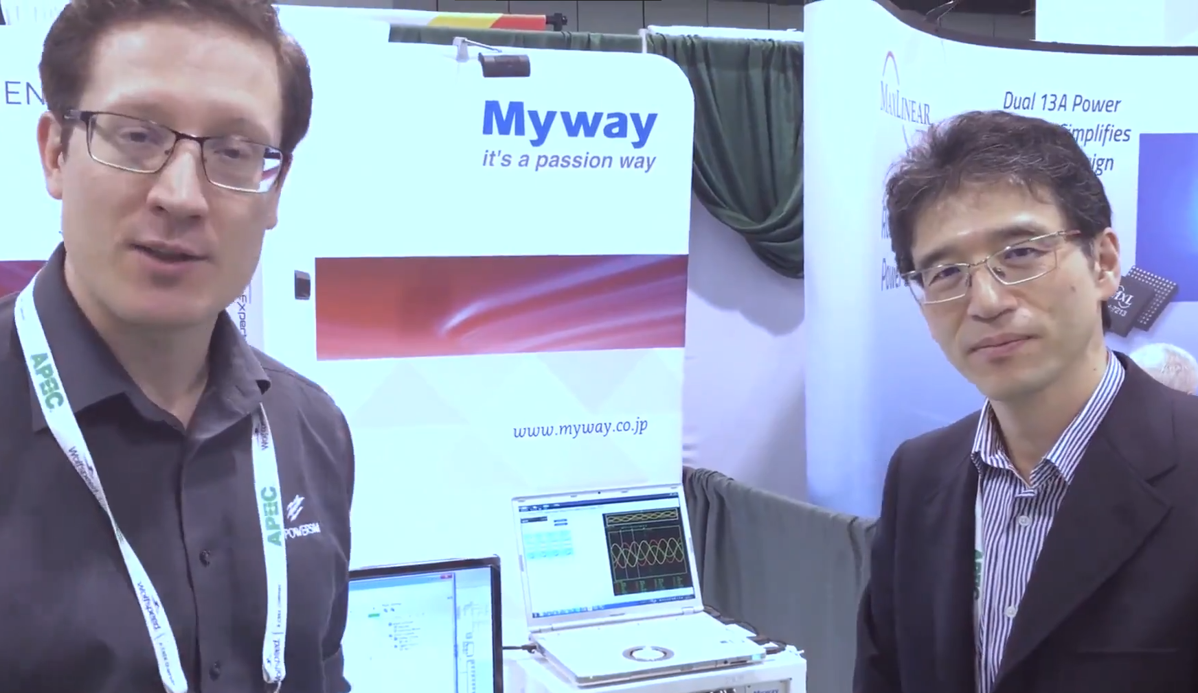 Two people standing in front of the Myway banner.